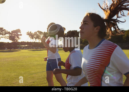 Soccer players hitting the ball with head while practicing on the field Stock Photo