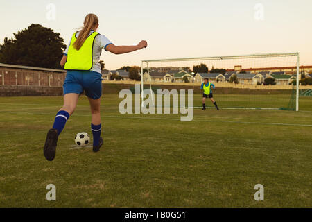 Players playing soccer at sports field Stock Photo