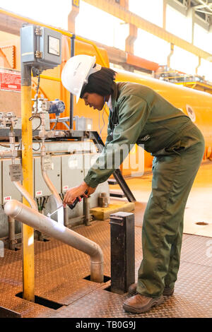 Johannesburg, South Africa - April 12 2012: Female Technician in turbine room at Coal Burning Power Station Stock Photo