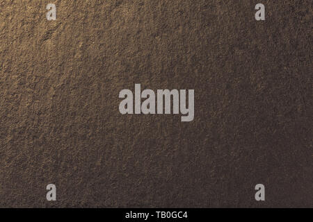 Dark bronze background of natural slate. Texture of brown stone closeup. Graphite golden backdrop macro Stock Photo