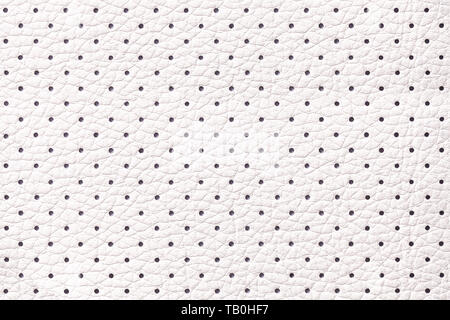 Perforated white leather texture background, closeup. Light ivory backdrop from wrinkle skin, structure of textile. Stock Photo
