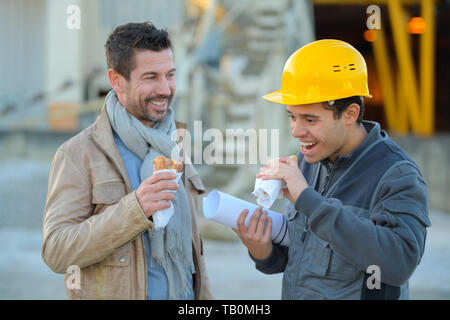 builders laughing while having a lunch break Stock Photo