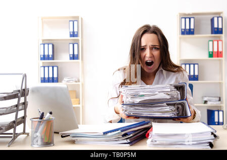 Young female employee unhappy with excessive work Stock Photo