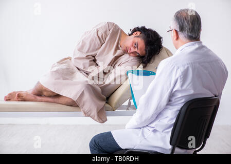 The aged male doctor psychiatrist examining young patient Stock Photo