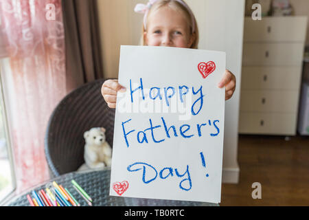 Daughter congratulates dad and gives him gift and postcard Stock Photo