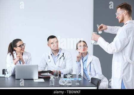 Doctor conducting experiment during lecture for interns in clinic Stock Photo