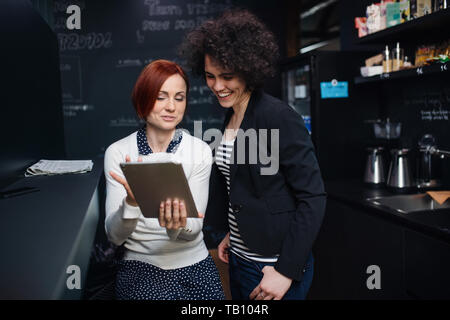 Two young businesspeople using tablet in office, start-up concept. Stock Photo