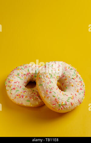 two white donuts on yellow background top view copy space Stock Photo