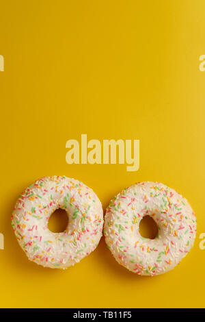 two white donuts on yellow background top view copy space Stock Photo