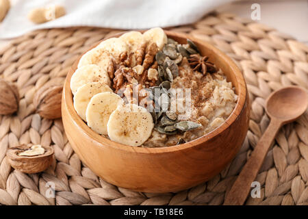 Bowl with tasty oatmeal on table Stock Photo