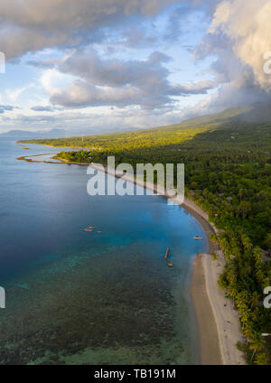 Clouds drift over the scenic coastline of Flores, Indonesia. This large island is surrounded by vibrant coral reefs. Stock Photo