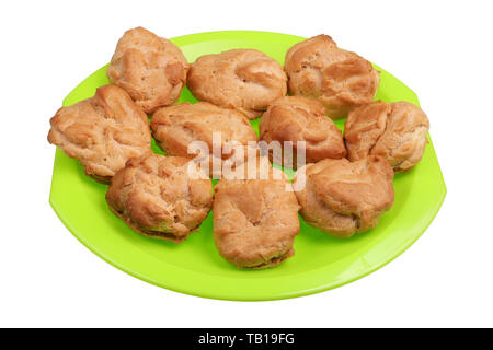 Homemade soft sweet eclairs pastries in rural style on a green plate. Isolated on white studio macro shot Stock Photo