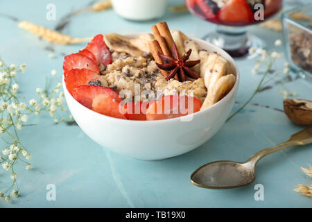 Bowl with tasty oatmeal on light table Stock Photo