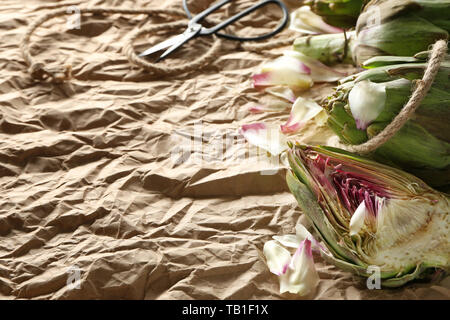 Tasty raw artichokes on paper background Stock Photo