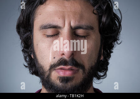 Man with Beard and Long Hair Crying with Closed Eyes Stock Photo