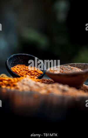 Close up of raw pink lentils in a clay bowl on wooden surface with its powder. Stock Photo