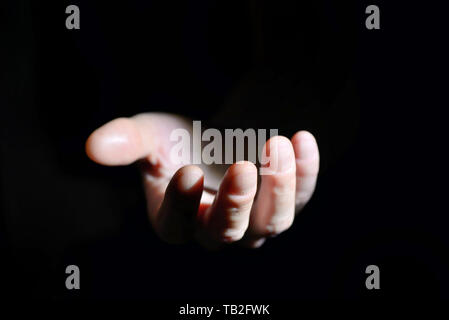 Symbolic hand helping on black background Stock Photo