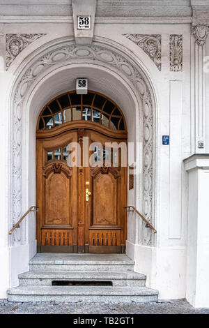 Schöneberg-Berlin. Decorative entrance with wooden door & sculptural details on Historic listed building on Viktoria Luise Platz Stock Photo