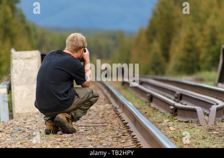 A photographer take a photo of two grizzly bears on the rail tracks , close up Stock Photo