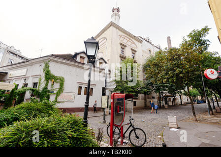 Belgrade, Serbia - June 16, 2018. Historic place Skadarlija with phone booth, trees, lamppost, bicycle and cobbled lane in downtown. Bohemian street w Stock Photo