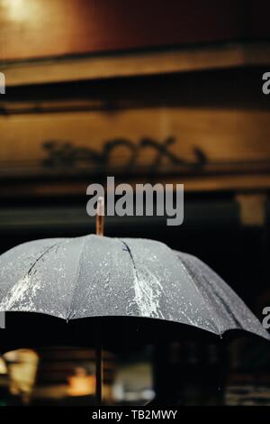 Wet black stained umbrella after rain Stock Photo