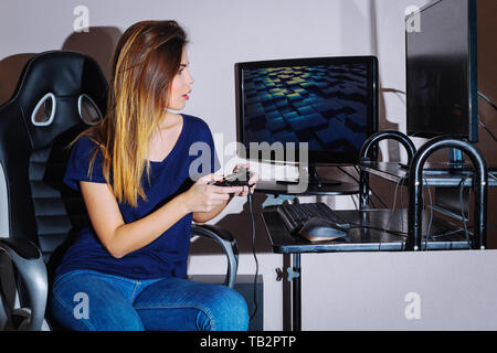 A young woman is playing a computer game Stock Photo
