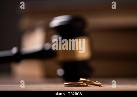 Judge gavel with wedding rings on wooden table. Close up Stock Photo