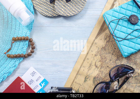 Travel holiday supplies: hat, sunglasses, flip flops, camera, passport and airline tickets on blue background. The concept of going on a trip to the s Stock Photo