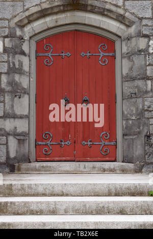 Stone steps and red wooden door of a church Stock Photo