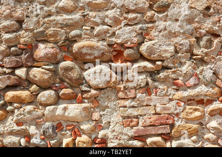 Old bricks and stones wall texture background, sunlight Stock Photo