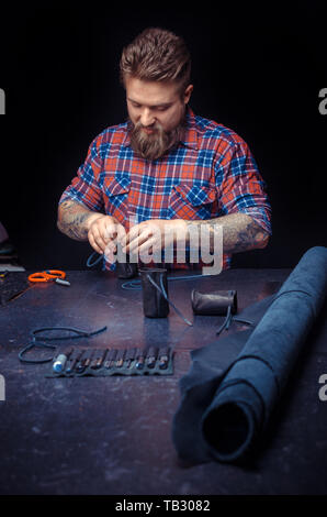 Tanner of leather creating a new leather product at the studio. Stock Photo