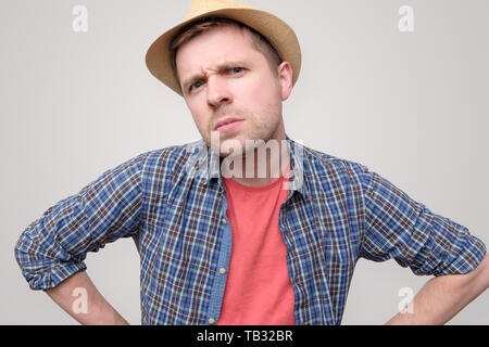 man in summer hat frowning being angry. Stock Photo