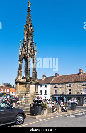 dh Market place HELMSLEY NORTH YORKSHIRE People relaxing by Lord Feversham monument Stock Photo