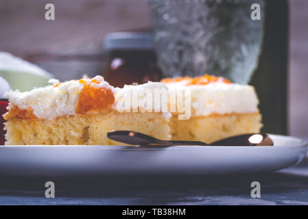 Horizontal photo of few pieces of homemade cakes. Cake are from light dough with cream topping which is full of tangerine pieces. Cakes are on white c Stock Photo
