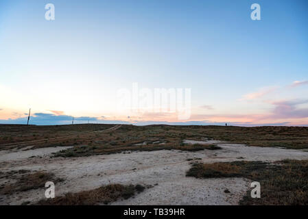 Semi-desert landscape with rural road and sky Stock Photo