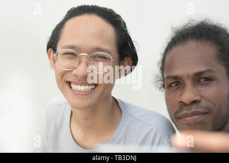 two friend with diffrent ethnic taking selfie together and smiling, asian and black man selfie toghether Stock Photo