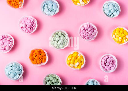 Multicolored chocolate frosting for making desserts in cupcake shapes on a pink background. Professional pastry chef concept. Top view, flat lay Stock Photo