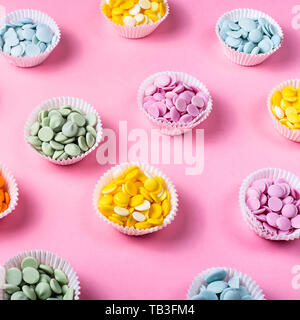 Multicolored chocolate frosting for making desserts in cupcake shapes on a pink background. Professional pastry chef concept Stock Photo