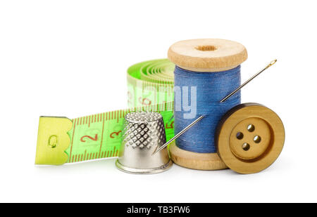 Spool of blue thread, needle, button, measuring tape and thimble isolated on white Stock Photo