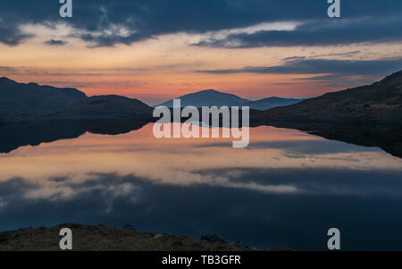 Sunrise in Snowdonia, golden hour and red moody skies in the early morning. Stock Photo