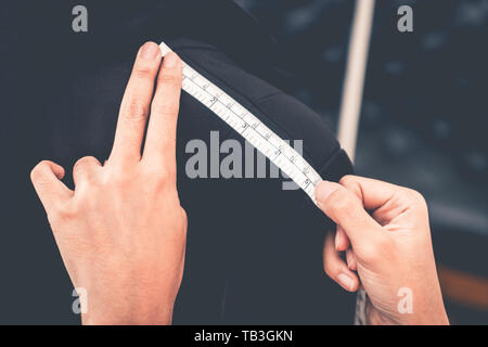 Fashion Designer hand is measuring shoulder with measuring tape Stock Photo