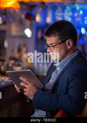 He cannot get away from his job even in the bar Stock Photo