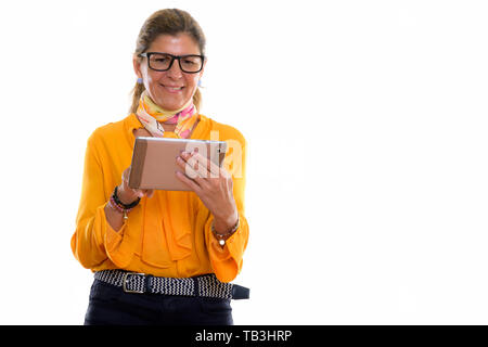 Studio shot of mature happy businesswoman smiling and using digi Stock Photo