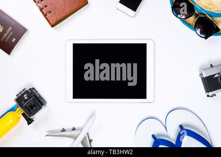 Blank tablet screen surrounding by travel objects Stock Photo