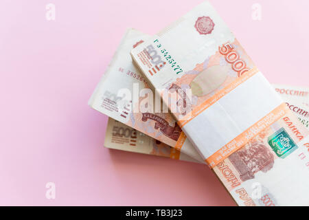 Stack of 5000 rubles packs isolated on pink. The concept of wealth, profits, business and finance. Stack money in the five thousandth bills banknotes Stock Photo