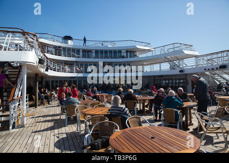 Passengers enjoy the sunshine on the aft outer decks of the Marco Polo in The North Atlantic Ocean Stock Photo