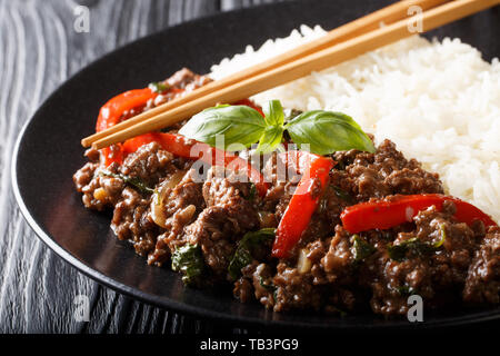 Stir-fried Thai Pad Gra Prow with rice side dish close-up on a plate on the table. horizontal Stock Photo