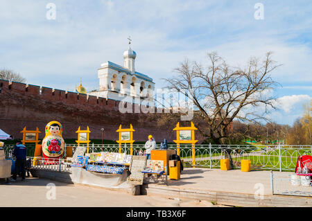 Veliky Novgorod, Russia -May 2, 2018. Belfry of St Sophia cathedral with big colorful Russian doll matrioshka on the foreground and souvenirs in Velik Stock Photo