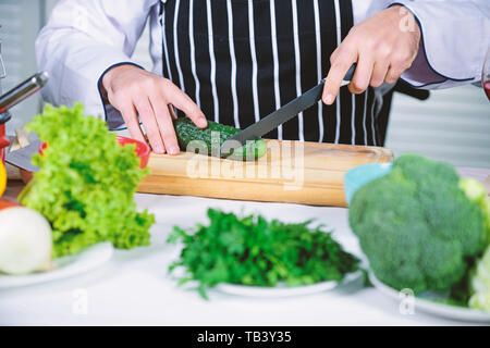 At work. Chef man in apron. Secret taste recipe. Vegetarian. Bearded man cook in kitchen, culinary. Dieting and organic food, vitamin. Healthy food cooking. Stock Photo