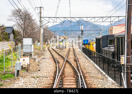 Railway tracks with switch near a small train station in the mountains on a sunny spring day. Fujiyoshida, Japan Stock Photo